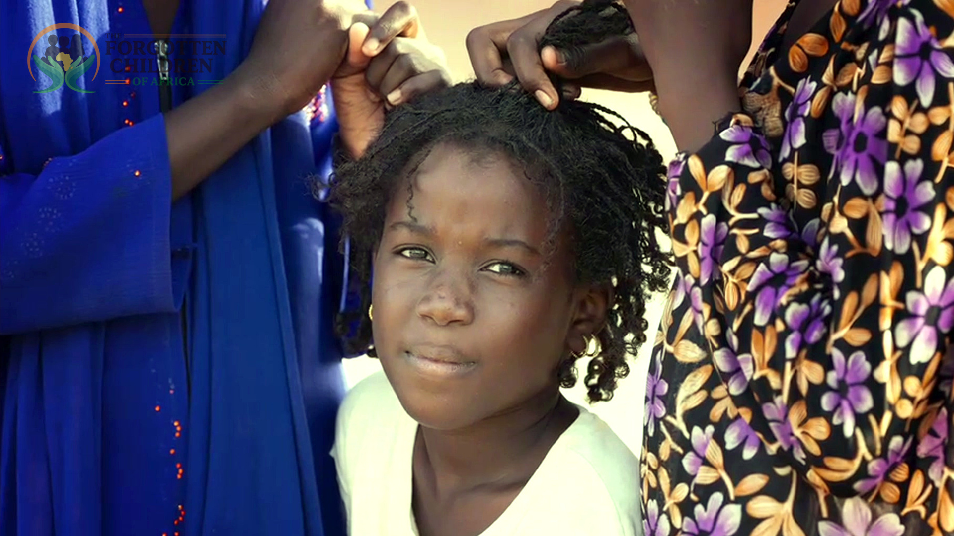 A girl having her hair braided.