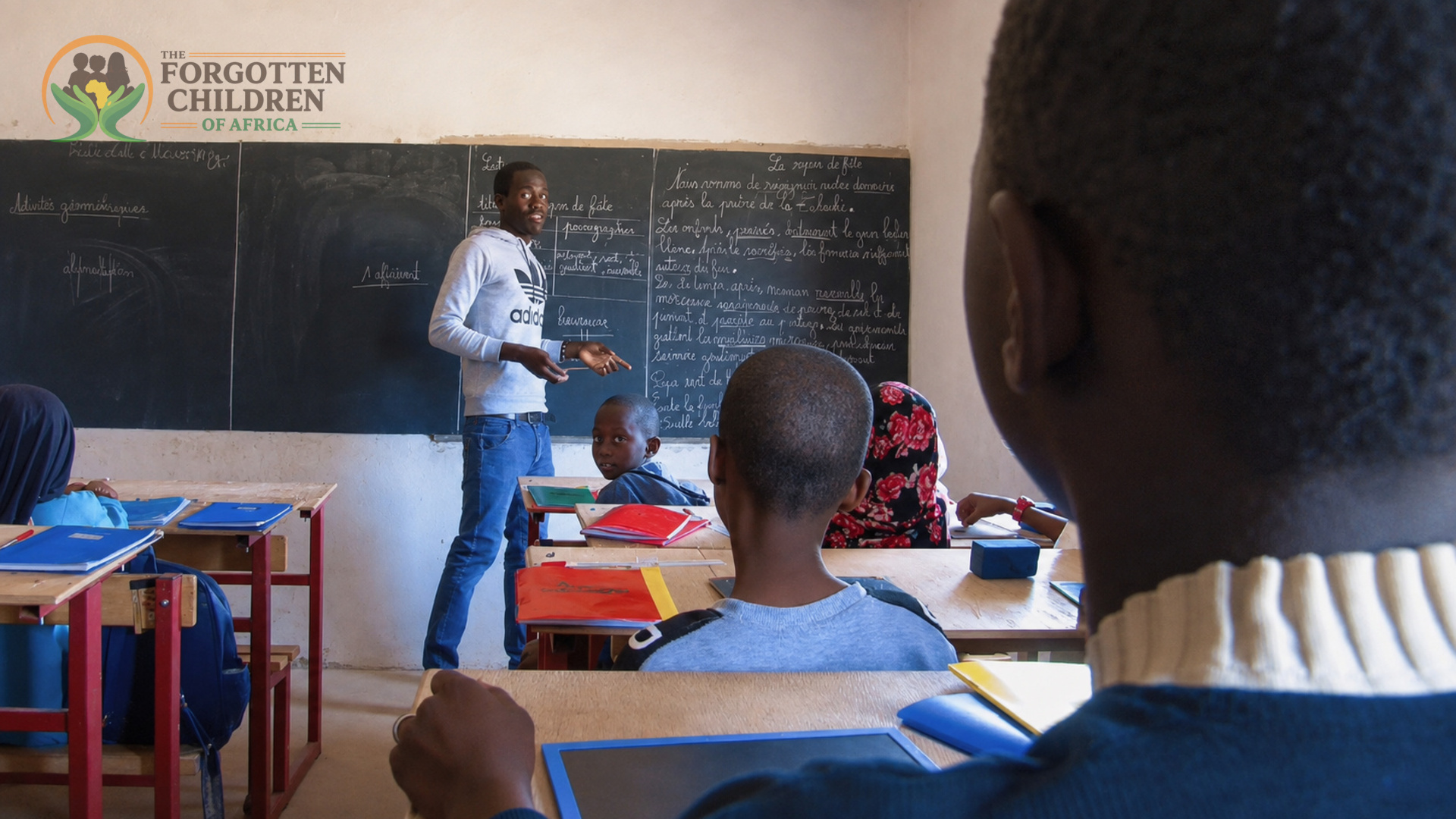 Teacher writing on the classroom blackboard