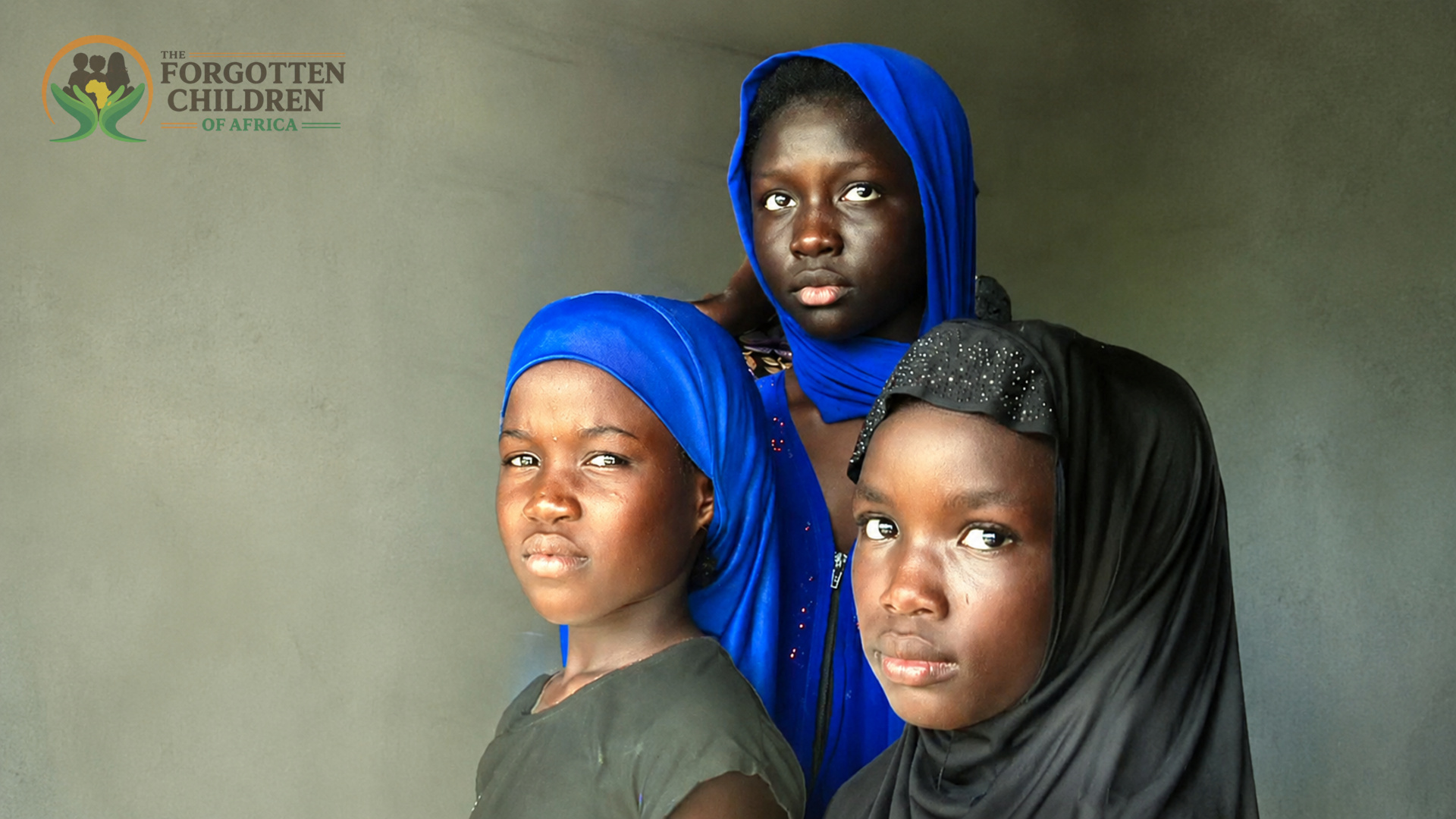 Three girls in blue and black headscarves
